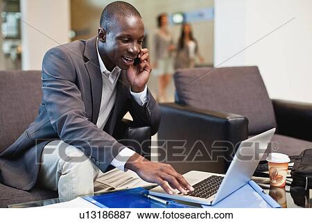 Businessman working in lobby View Large Photo Image Stock Photo - Businessman working in lobby. Fotosearch