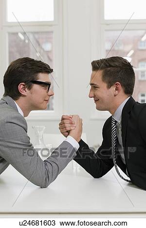 Businessmen arm wrestling in office View Large Photo Image Stock Image - Businessmen arm wrestling in office. Fotosearch
