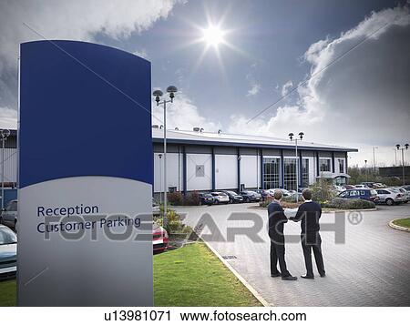 Businessmen standing in parking lot View Large Photo Image Stock Image - Businessmen standing in parking lot. Fotosearch