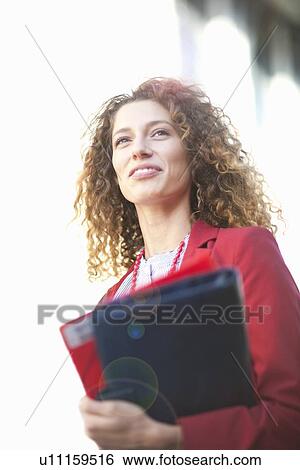 Businesswoman carrying folders outdoors View Large Photo Image Stock Photograph - Businesswoman carrying folders outdoors. Fotosearch