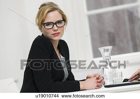 Businesswoman sitting at desk View Large Photo Image Picture - Businesswoman sitting at desk. Fotosearch