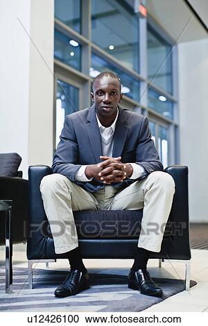 Stock Image - Businesswoman sitting in armchair. Fotosearch