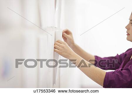 Businesswoman tacking up signs in office View Large Photo Image Stock Photograph - Businesswoman tacking up signs in office. Fotosearch