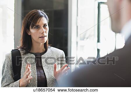 Picture - Businesswoman talking to colleague. Fotosearch