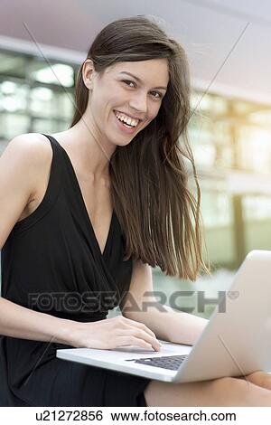 Stock Photograph - Businesswoman using laptop outdoors. Fotosearch