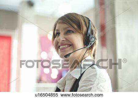 Businesswoman wearing headset at desk View Large Photo Image Stock Photography - Businesswoman wearing headset at desk. Fotosearch