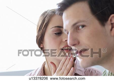 Stock Photograph - Businesswoman whispering to colleague. Fotosearch
