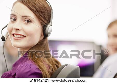 Stock Image - Businesswoman working in headset. Fotosearch
