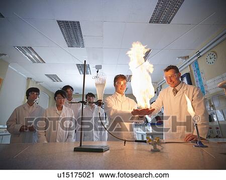 Stock Image - Chemistry teacher and students in lab. Fotosearch