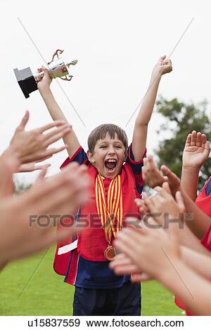 Children cheering teammate with trophy View Large Photo Image Stock Photo - Children cheering teammate with trophy. Fotosearch