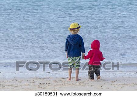 Children holding hands on sandy beach View Large Photo Image Stock Image - Children holding hands on sandy beach. Fotosearch