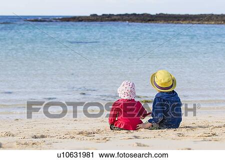 Children sitting on sandy beach View Large Photo Image Stock Image - Children sitting on sandy beach. Fotosearch
