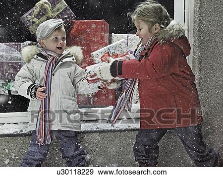 Stock Photo - Children with Christmas gifts in snow. Fotosearch