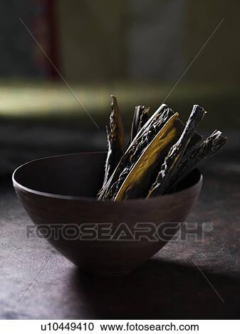 Stock Image - Close up of herbs in bowl. Fotosearch