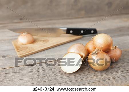 Picture - Close up of onions and knife on table. Fotosearch