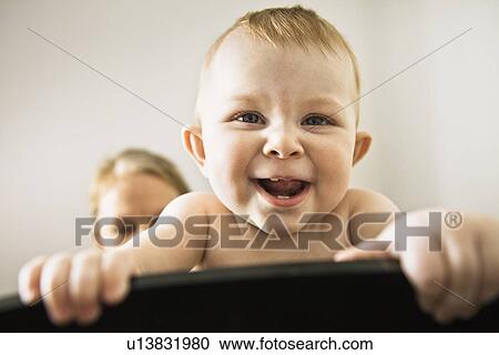 Stock Image - Close up of smiling baby girls face. Fotosearch