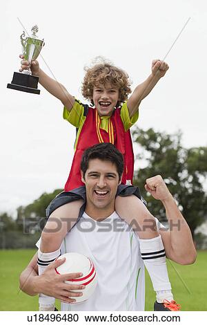 Coach carrying child with trophy View Large Photo Image Stock Image - Coach carrying child with trophy. Fotosearch