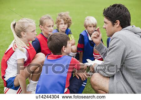 Coach talking to childrens soccer team View Large Photo Image Picture - Coach talking to childrens soccer team. Fotosearch
