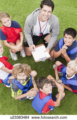 Picture - Coach talking to childrens soccer team. Fotosearch