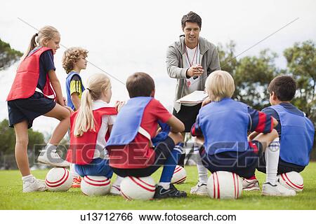Coach talking to childrens soccer team View Large Photo Image Stock Photograph - Coach talking to childrens soccer team. Fotosearch