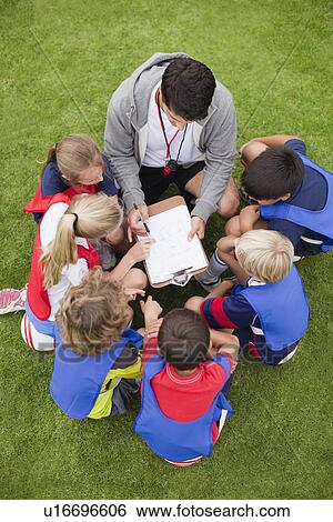 Stock Photograph - Coach talking to childrens soccer team. Fotosearch