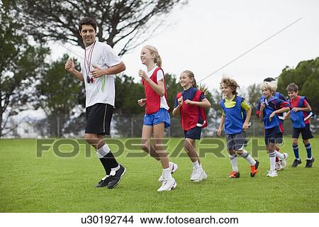 Coach training children on field View Large Photo Image Picture - Coach training children on field. Fotosearch