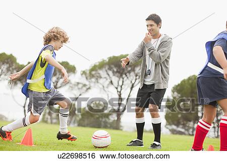 Coach training childrens soccer team View Large Photo Image Stock Photograph - Coach training childrens soccer team. Fotosearch