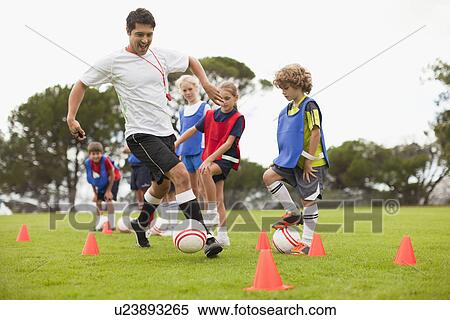 Stock Photography - Coach training childrens soccer team. Fotosearch