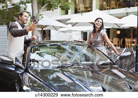 Couple climbing out of car View Large Photo Image Stock Photo - Couple climbing out of car. Fotosearch