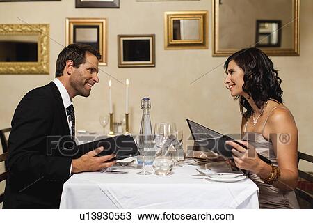 Couple examining menus in restaurant View Large Photo Image Stock Image - Couple examining menus in restaurant. Fotosearch