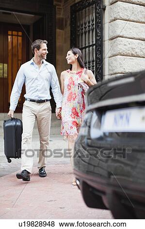 Couple walking to car on city street View Large Photo Image Stock Photo - Couple walking to car on city street. Fotosearch
