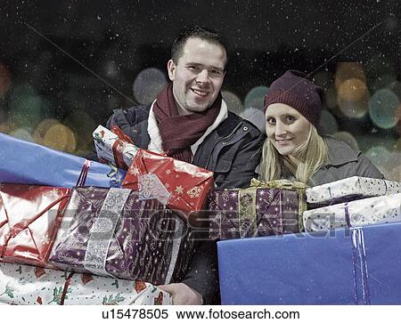 Couple with Christmas gifts in snow View Large Photo Image Stock Photography - Couple with Christmas gifts in snow. Fotosearch