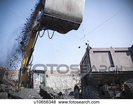 Stock Photo - Digger scooping coal at mine. Fotosearch