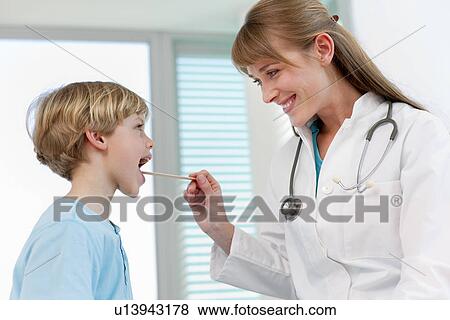 Doctor examining boy in office View Large Photo Image Stock Photo - Doctor examining boy in office. Fotosearch