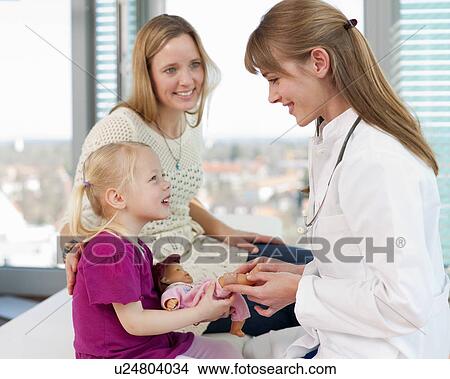 Picture - Doctor examining girls doll in office. Fotosearch