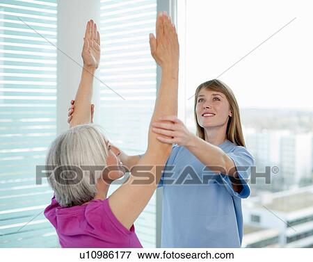 Stock Photo - Doctor examining womans arms in office. Fotosearch