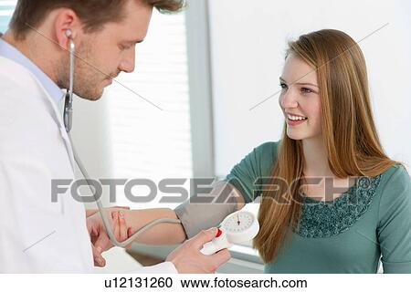 Doctor taking girls blood pressure View Large Photo Image Stock Image - Doctor taking girls blood pressure. Fotosearch