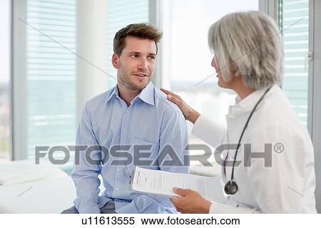 Stock Photography - Doctor talking to man in office. Fotosearch