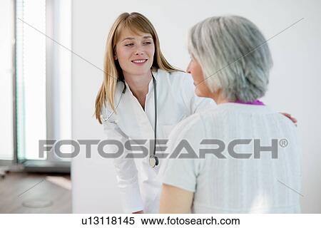 Doctor talking to woman in office View Large Photo Image Stock Photography - Doctor talking to woman in office. Fotosearch