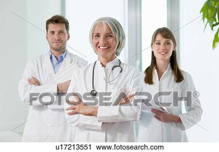 Stock Image - Doctors smiling together in hospital. Fotosearch