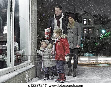 Family admiring Christmas window in snow View Large Photo Image Stock Photo - Family admiring Christmas window in snow. Fotosearch