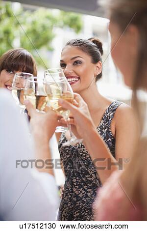 Stock Image - Friends toasting each other at party. Fotosearch