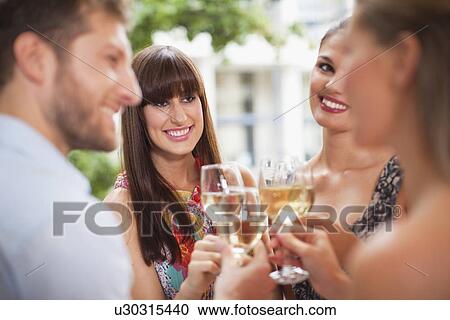 Stock Image - Friends toasting each other at party. Fotosearch