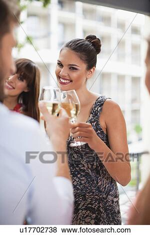 Stock Photo - Friends toasting each other at party. Fotosearch