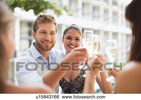 Stock Photograph - Friends toasting each other. Fotosearch