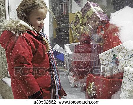 Girl admiring Christmas gifts in snow View Large Photo Image Stock Image - Girl admiring Christmas gifts in snow. Fotosearch