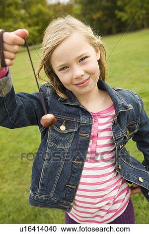 Stock Image - Girl playing with chestnut on string. Fotosearch