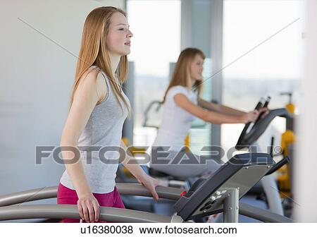 Stock Photo - Girl using treadmill in gym. Fotosearch