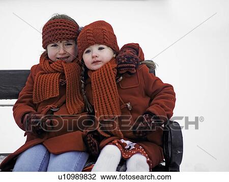 Girls sitting on bench in snow View Large Photo Image Stock Image - Girls sitting on bench in snow. Fotosearch
