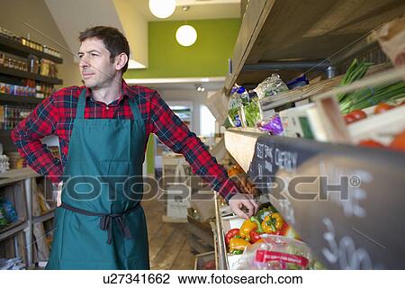 Grocer arranging produce for sale View Large Photo Image Stock Image - Grocer arranging produce for sale. Fotosearch